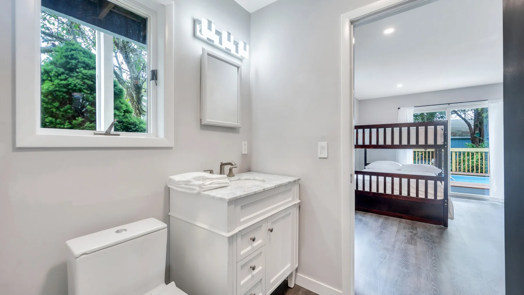 Un baño luminoso con un tocador blanco junto a una ventana.