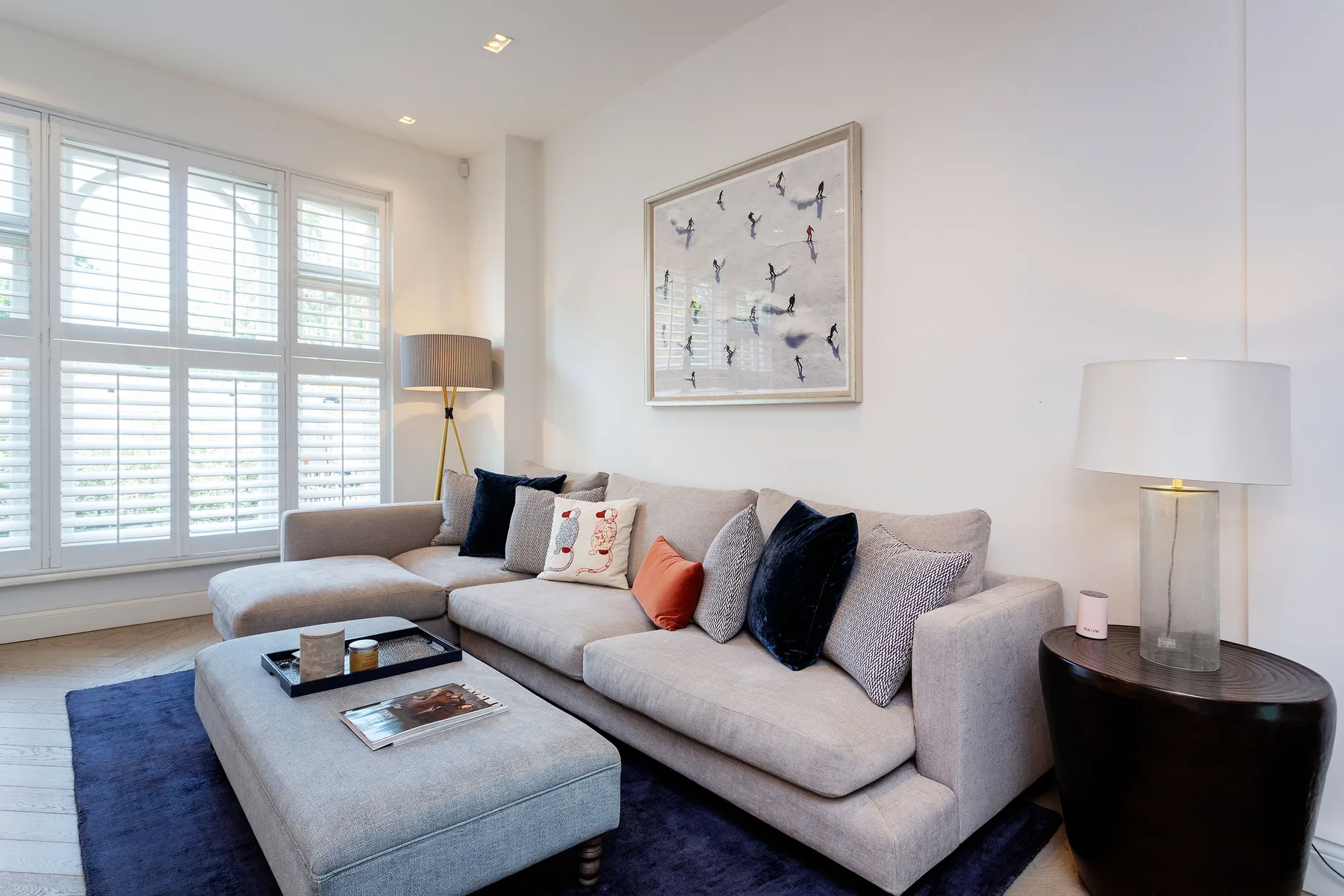 A bright living room with a sectional sofa and large windows.