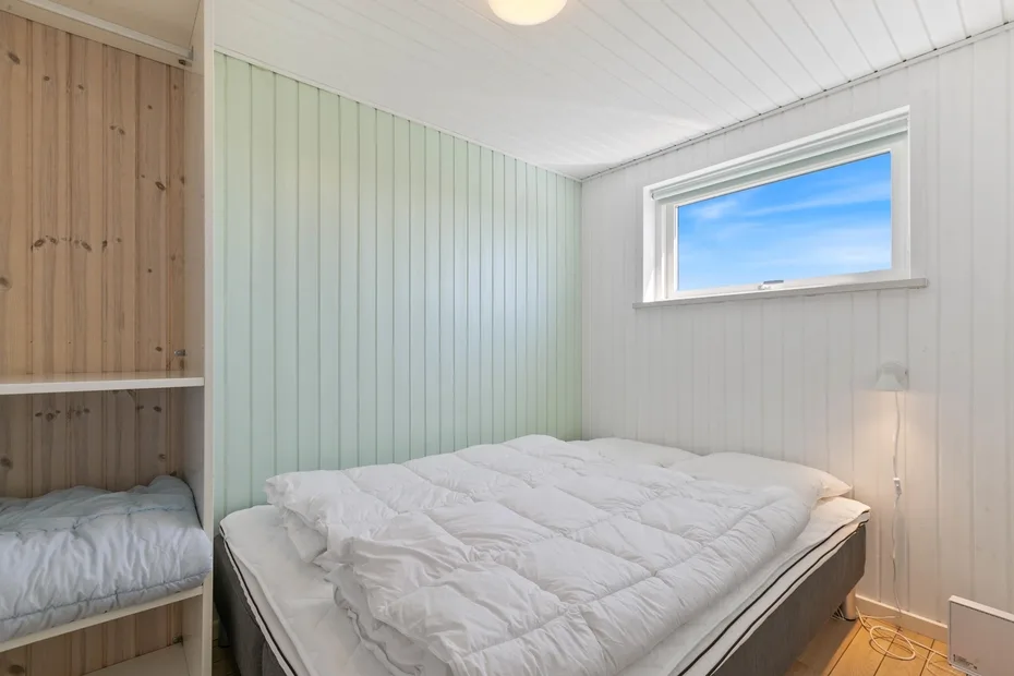 Un dormitorio con una cama y una ventana pequeña.