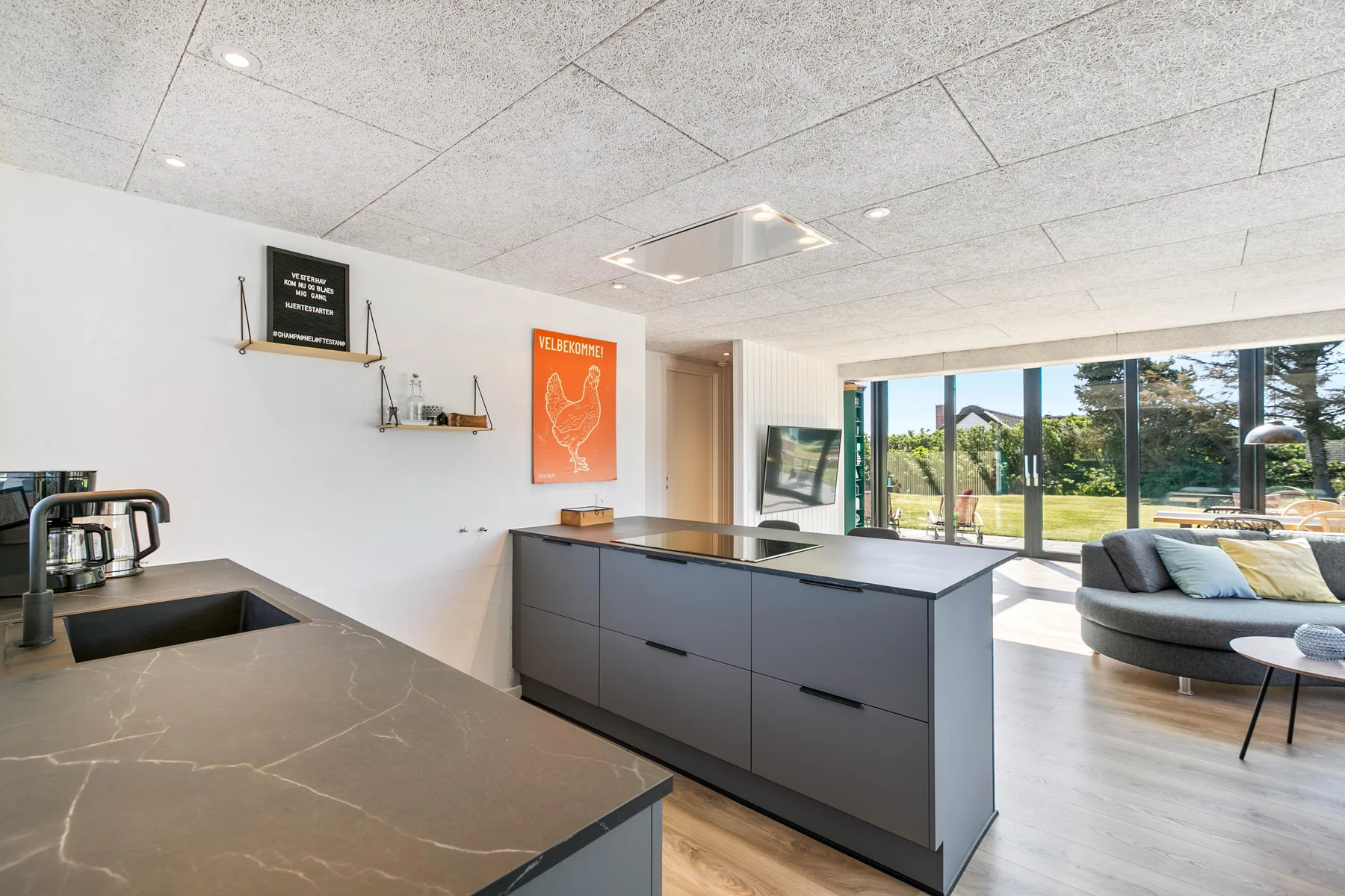Una cocina moderna con una isla amplia se abre a una luminosa sala de estar.
