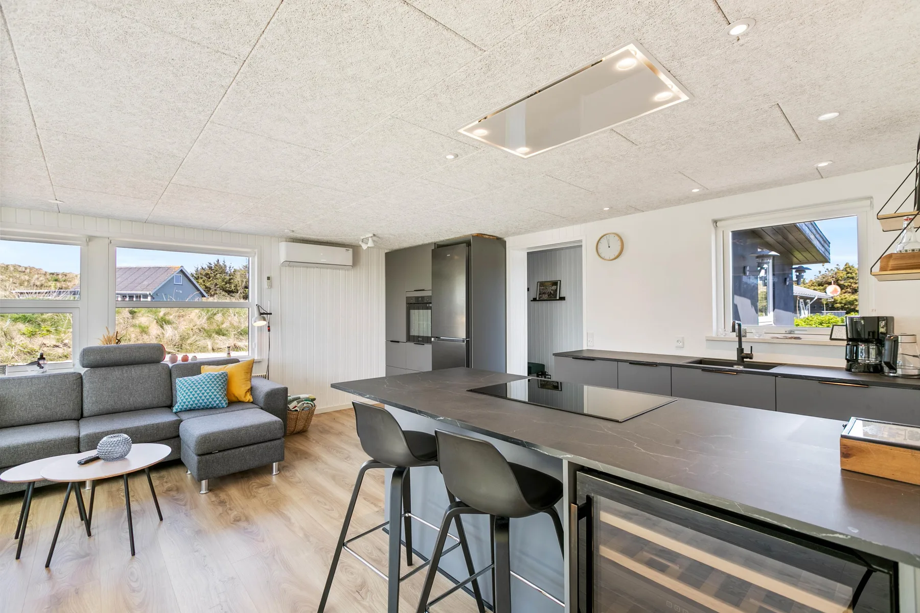 Cocina y sala de estar de concepto abierto con una isla grande y asientos.