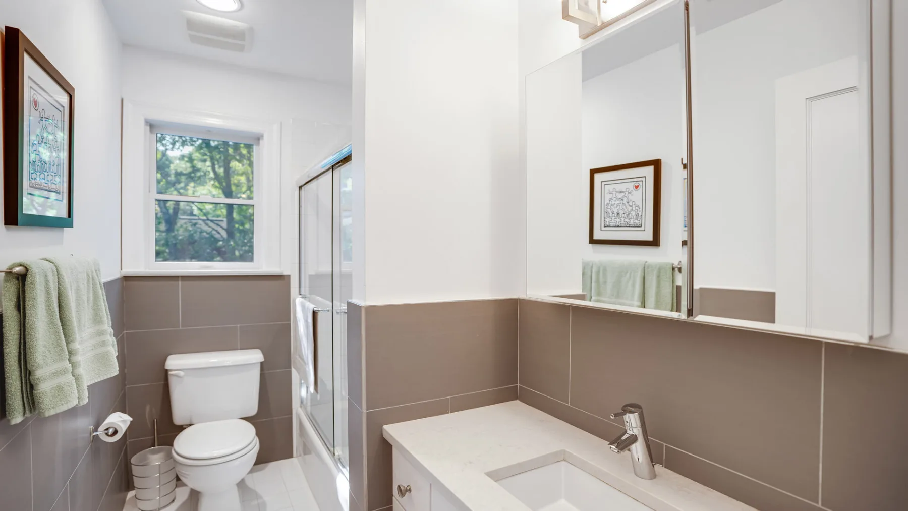 Un baño luminoso con lavabo, inodoro y ventana.