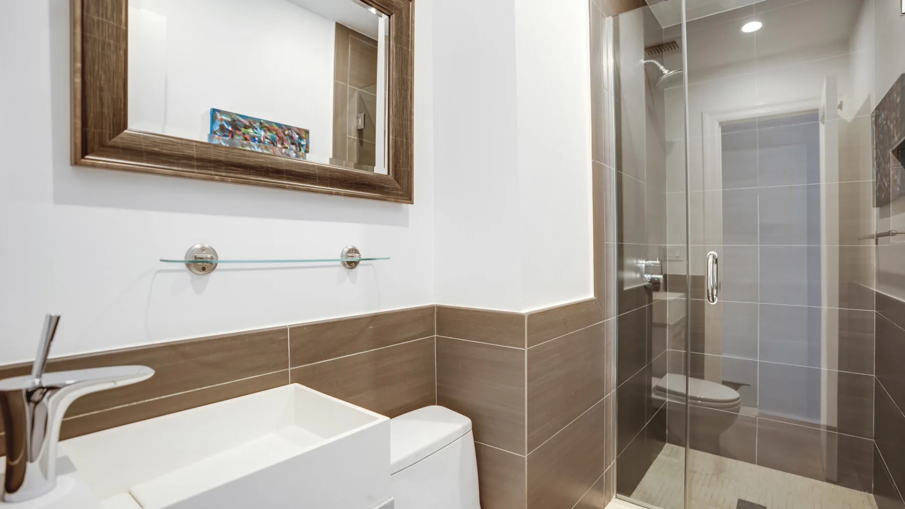 Un baño con lavabo, inodoro y ducha de vidrio.