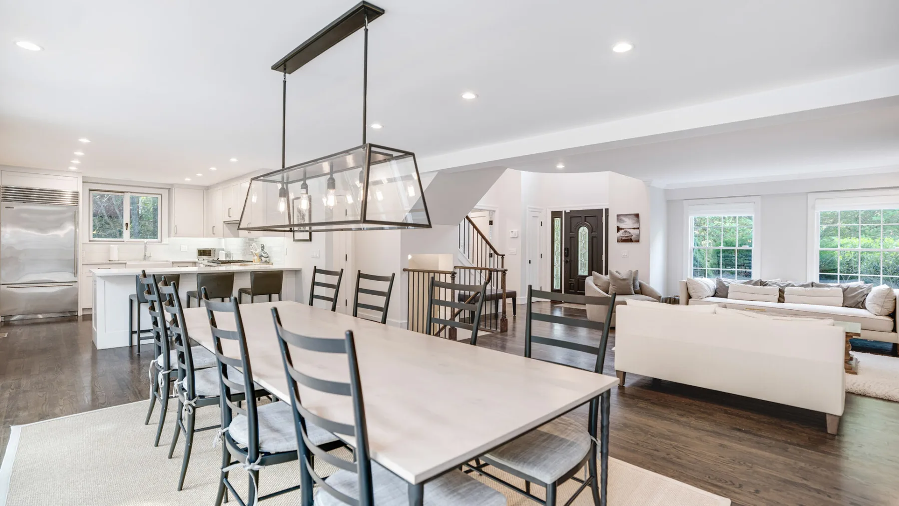 Un comedor y sala de estar de concepto abierto con una mesa larga y cocina.
