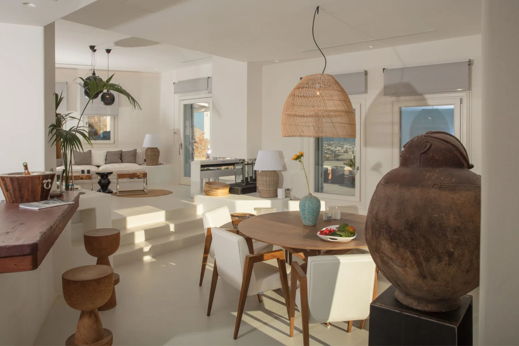 A bright open-plan living and dining area with a wooden table and seating.