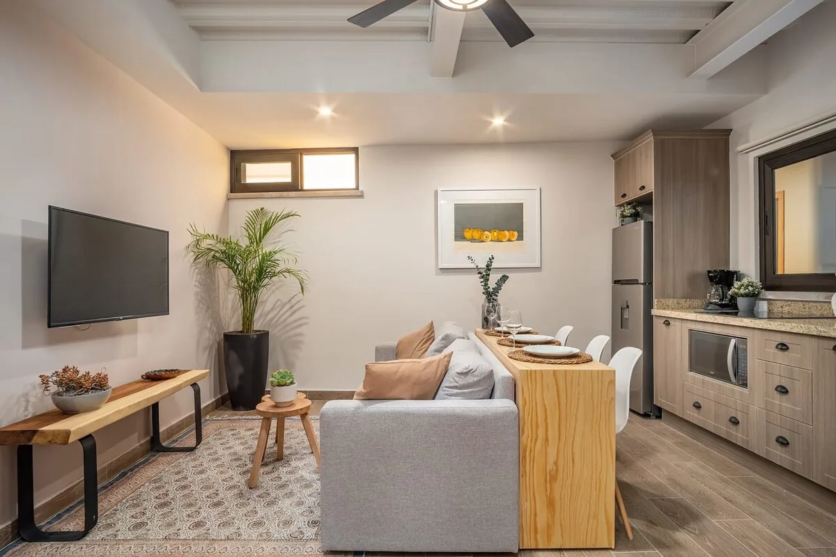 Sala de estar y cocina de concepto abierto con asientos, una barra de comedor y gabinetes de cocina.