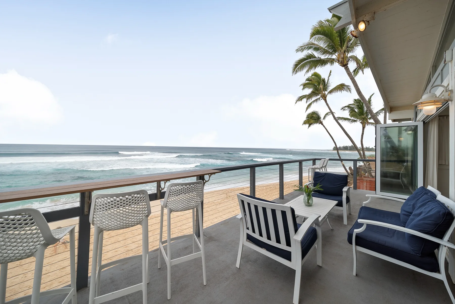 Un patio junto al mar con asientos al aire libre y vistas al agua.