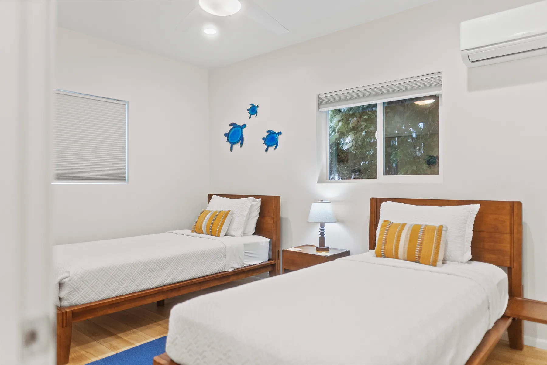 Un dormitorio luminoso con dos camas de madera y ventanas.