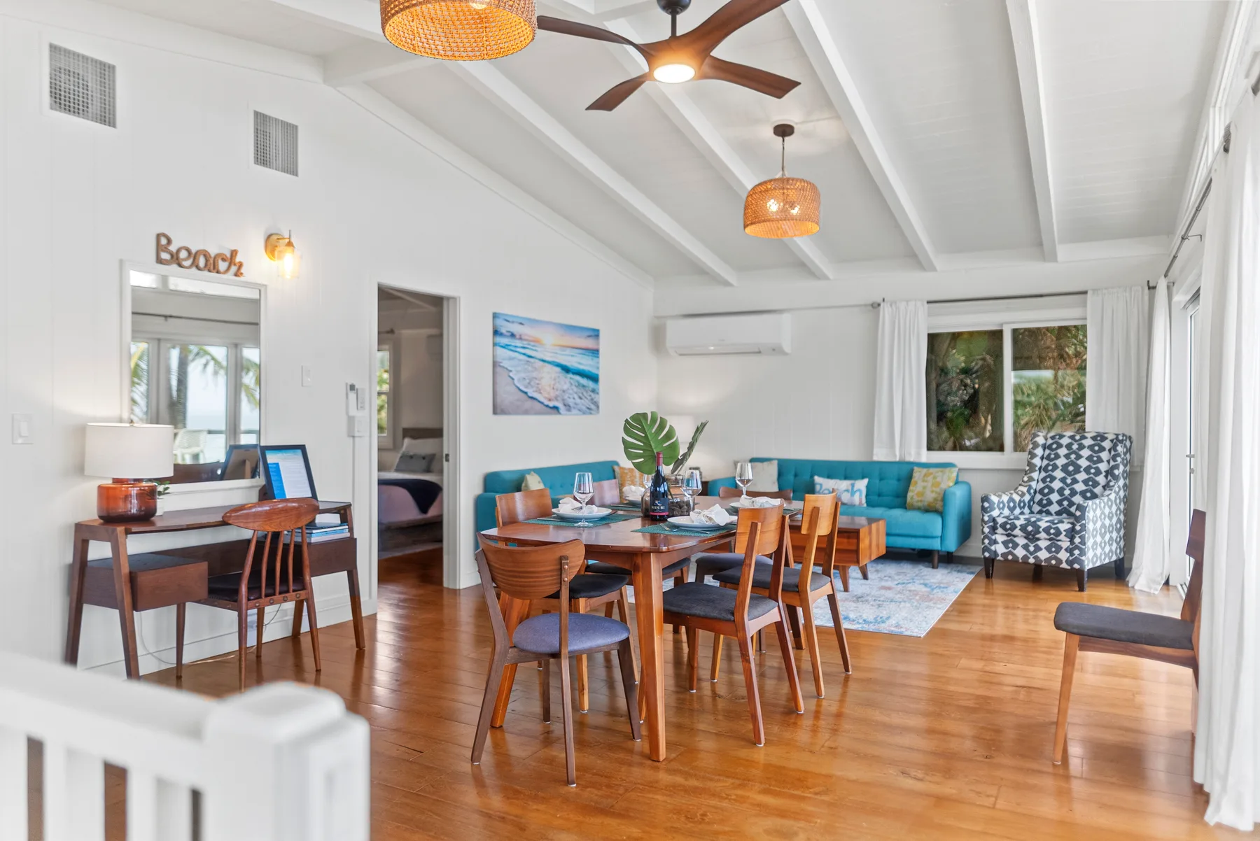 Una luminosa sala de estar y comedor con una mesa de madera y asientos azules.