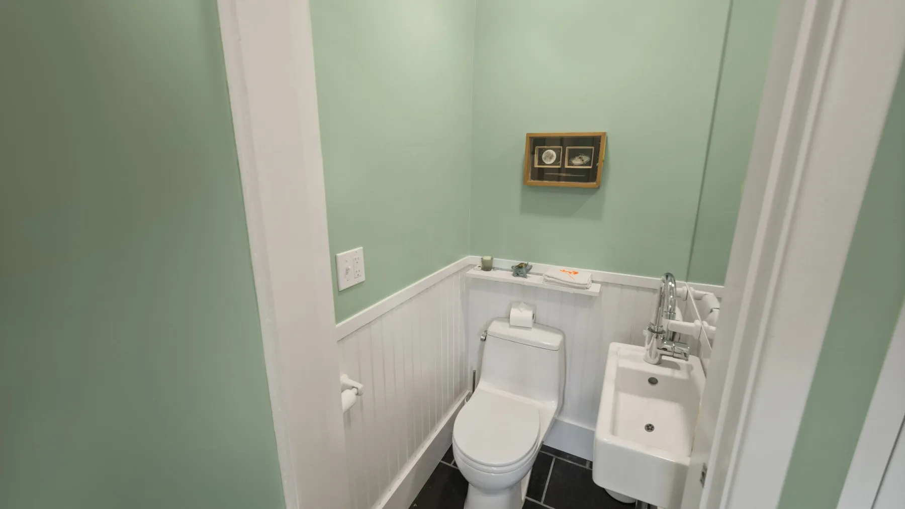 A compact bathroom with a toilet and wall-mounted sink.