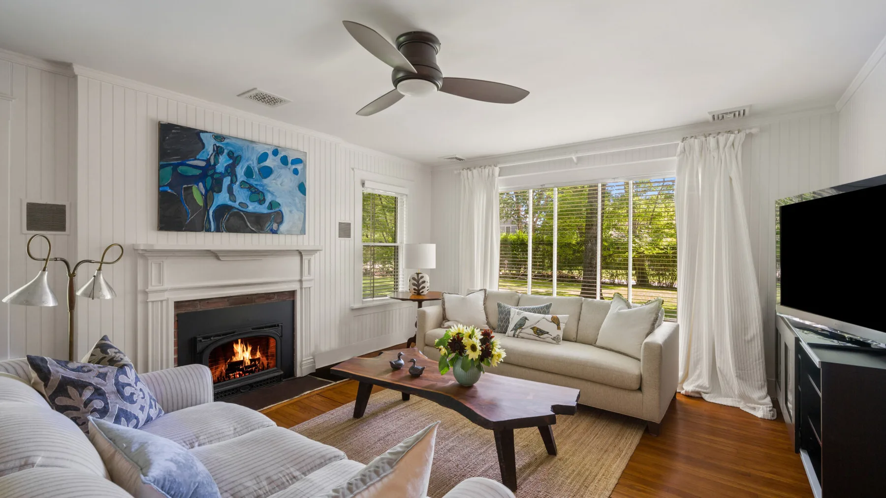 A bright living room with seating around a coffee table and a fireplace.