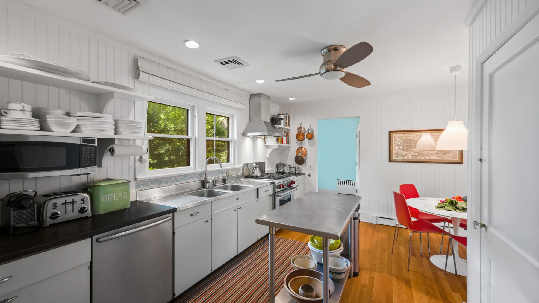 A bright kitchen and dining area with white cabinetry and a central island.