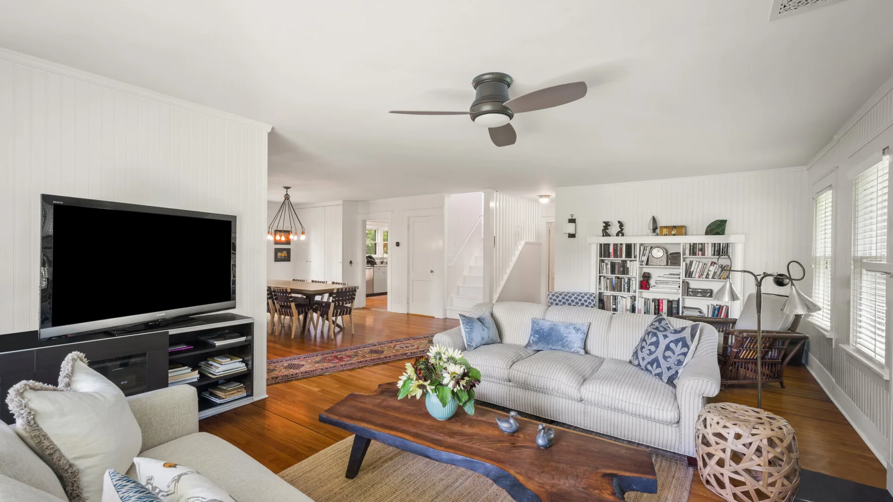A bright living room with seating, a television, and a low coffee table.