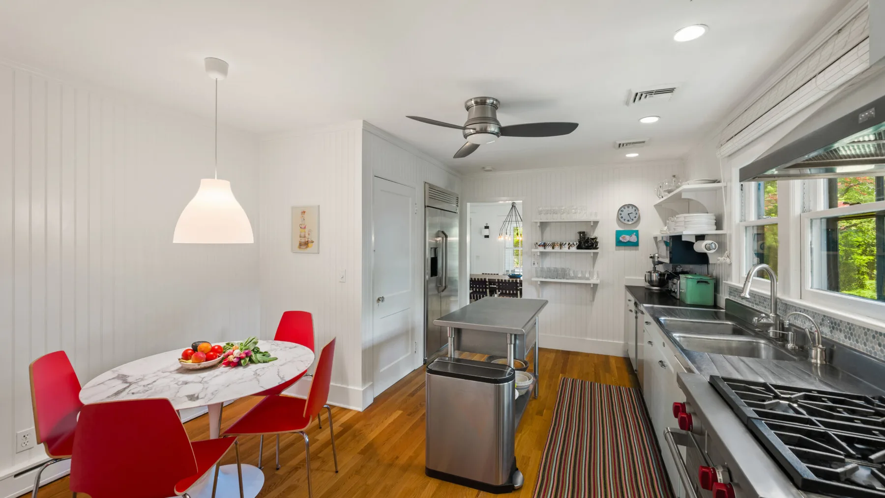 A bright kitchen and dining area with a table beside the cooking counters.