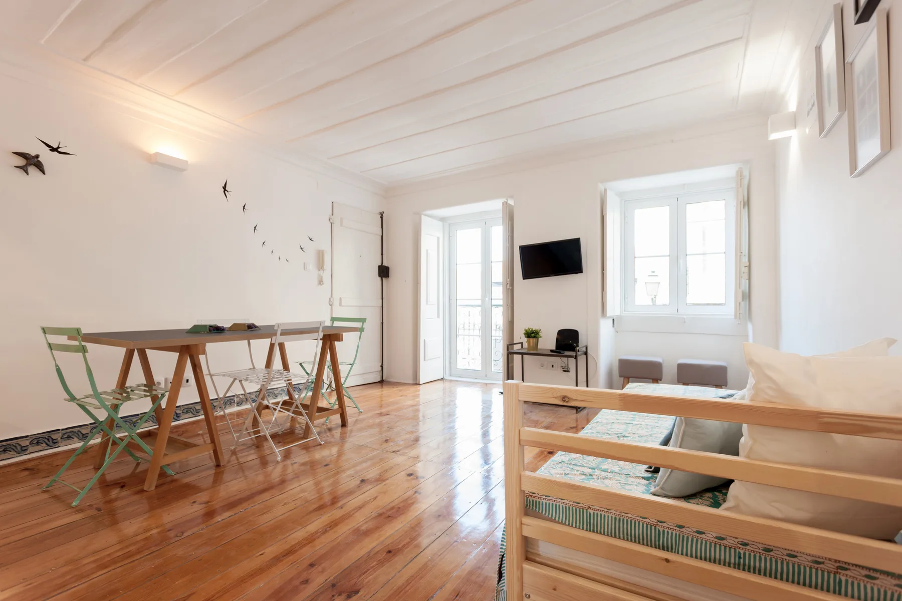 Una sala luminosa con una mesa de comedor y asientos junto a las ventanas.