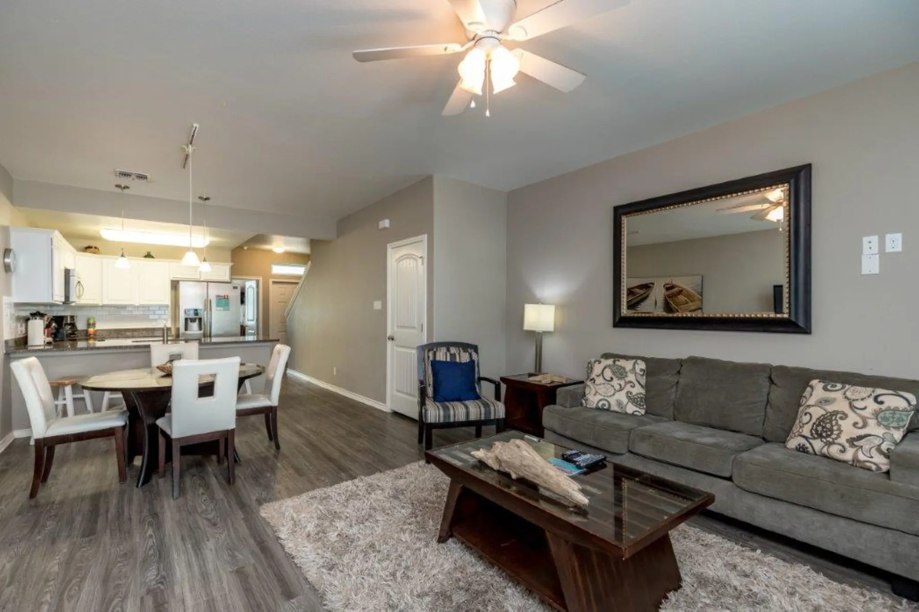 An open-plan living room and kitchen with a dining table and seating.