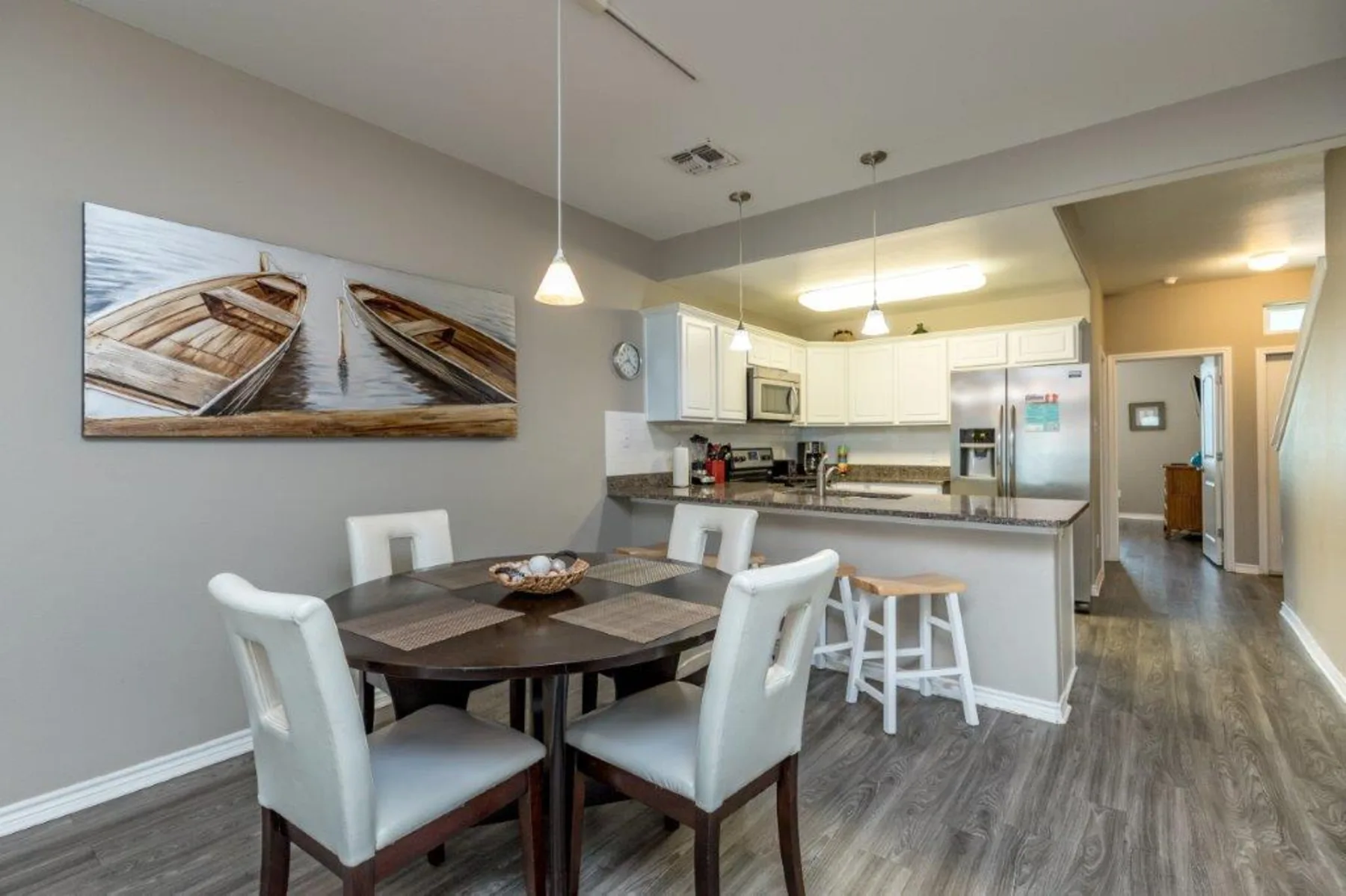 An open-plan dining area and kitchen with a dining table and counter seating.