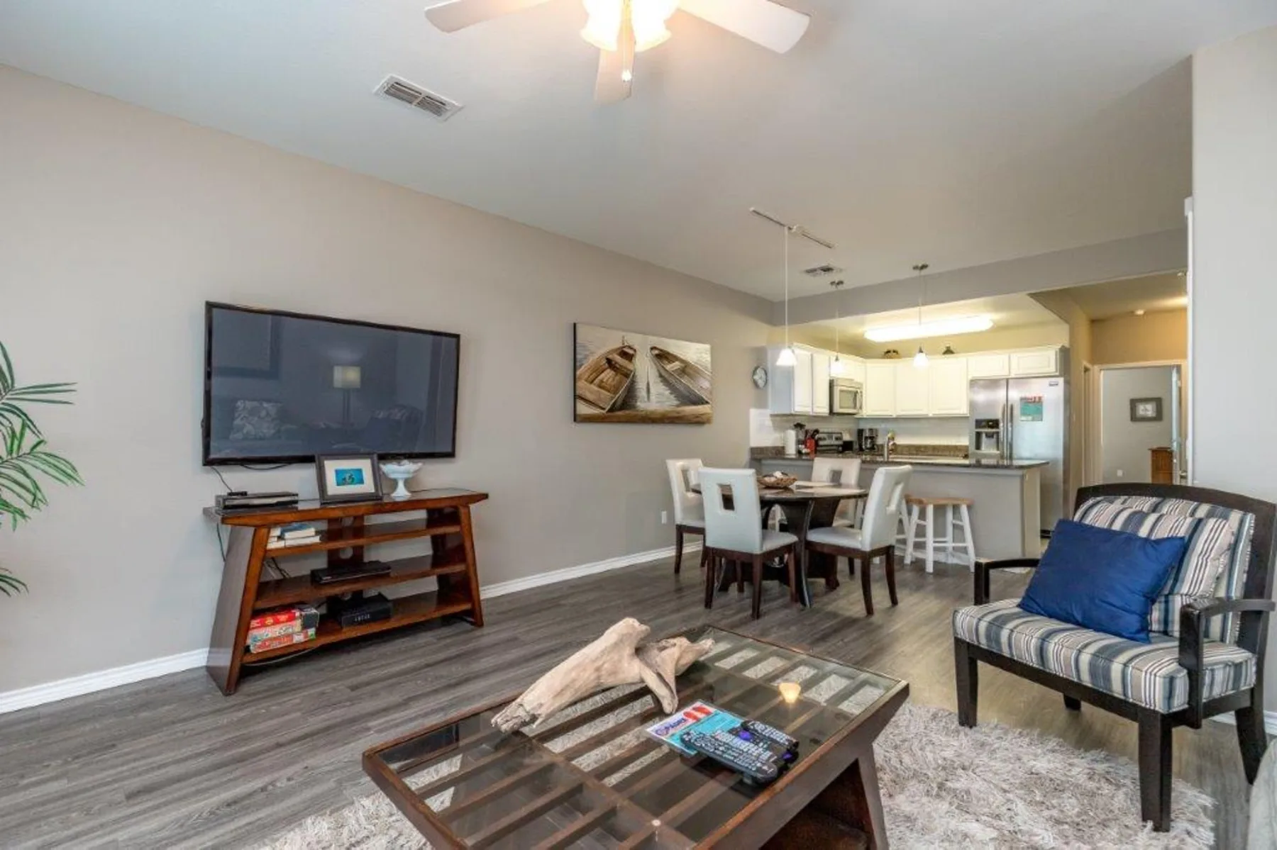 An open-plan living and dining area with a television and kitchen visible beyond.