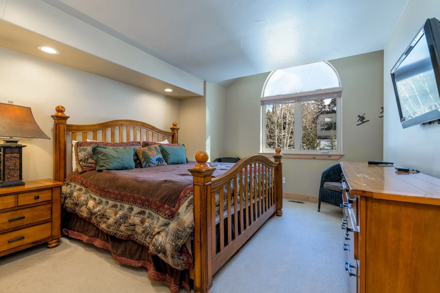 Un dormitorio con una cama de madera, una ventana y un escritorio.