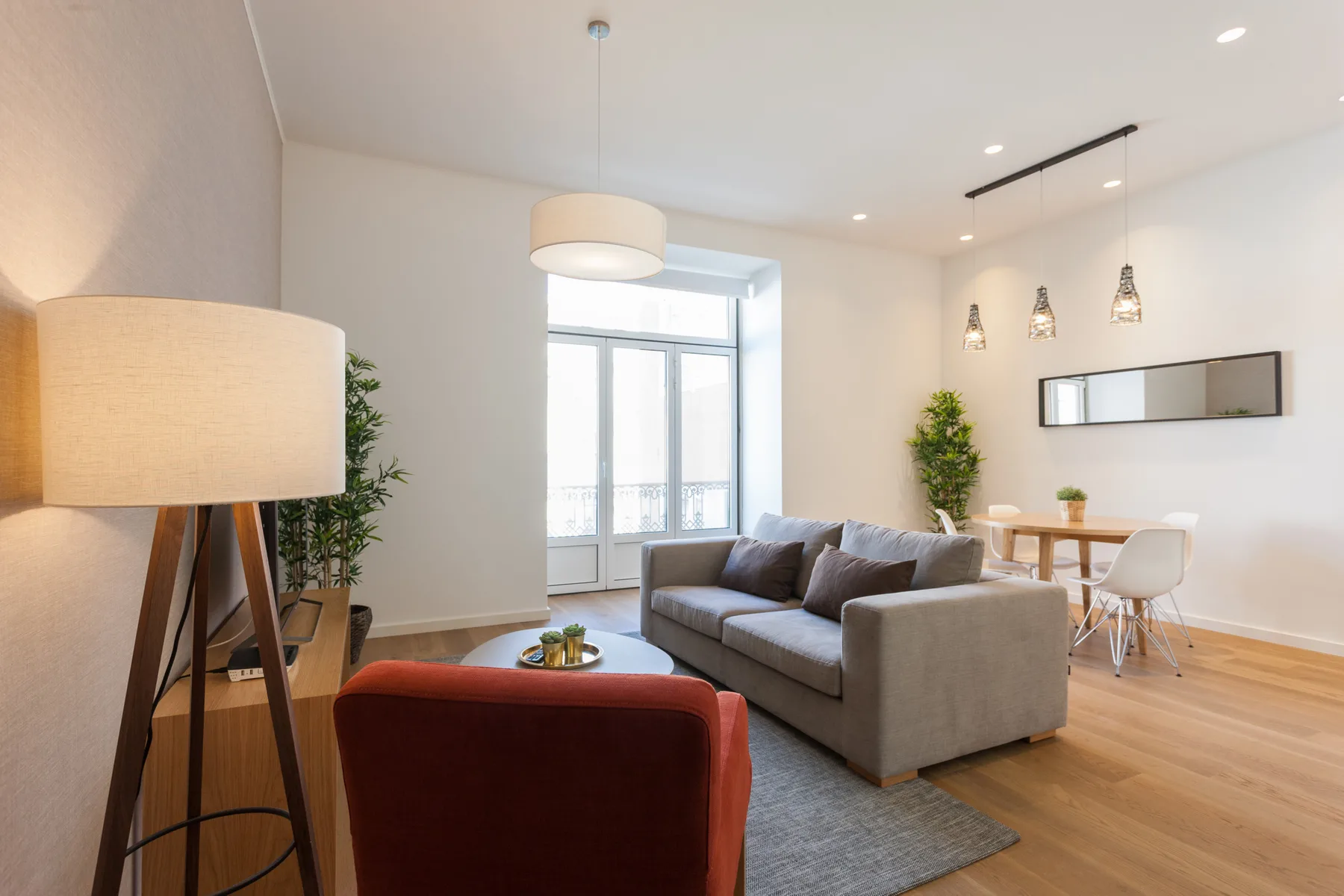 Una sala luminosa con asientos y un comedor junto a las ventanas.