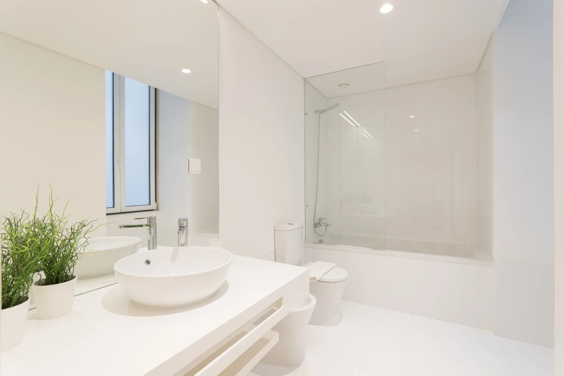 Un baño luminoso con lavabo, inodoro y bañera.