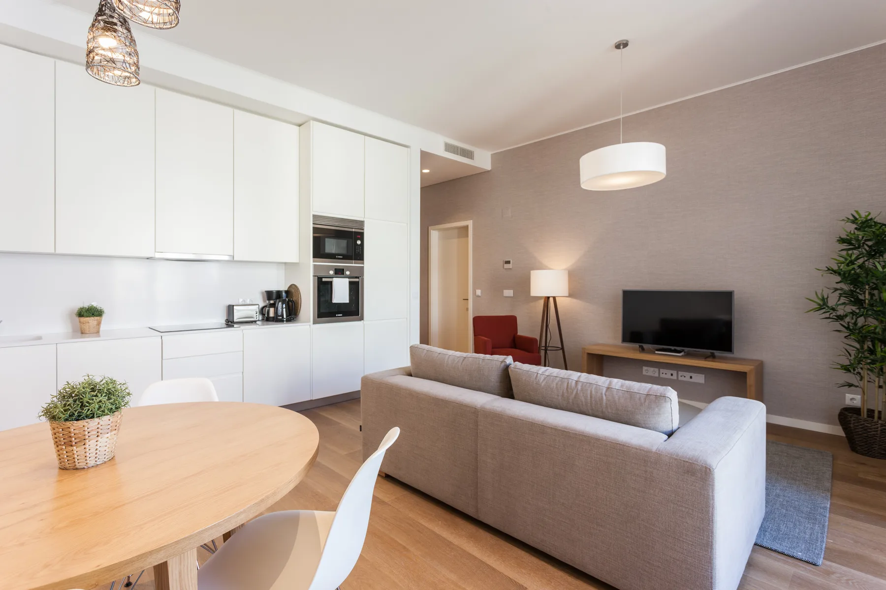 Sala de estar y cocina de concepto abierto con mesa de comedor y asientos.