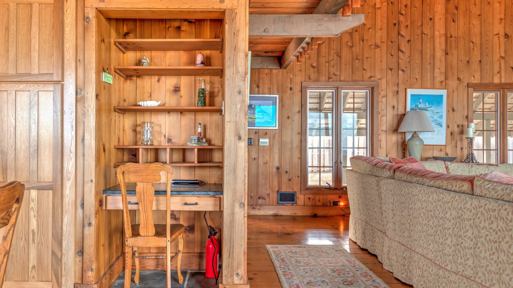 A wood-paneled living room with built-in shelving and seating.
