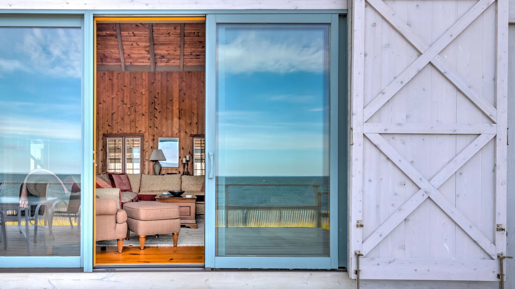 A living room opens onto a balcony through large sliding glass doors.