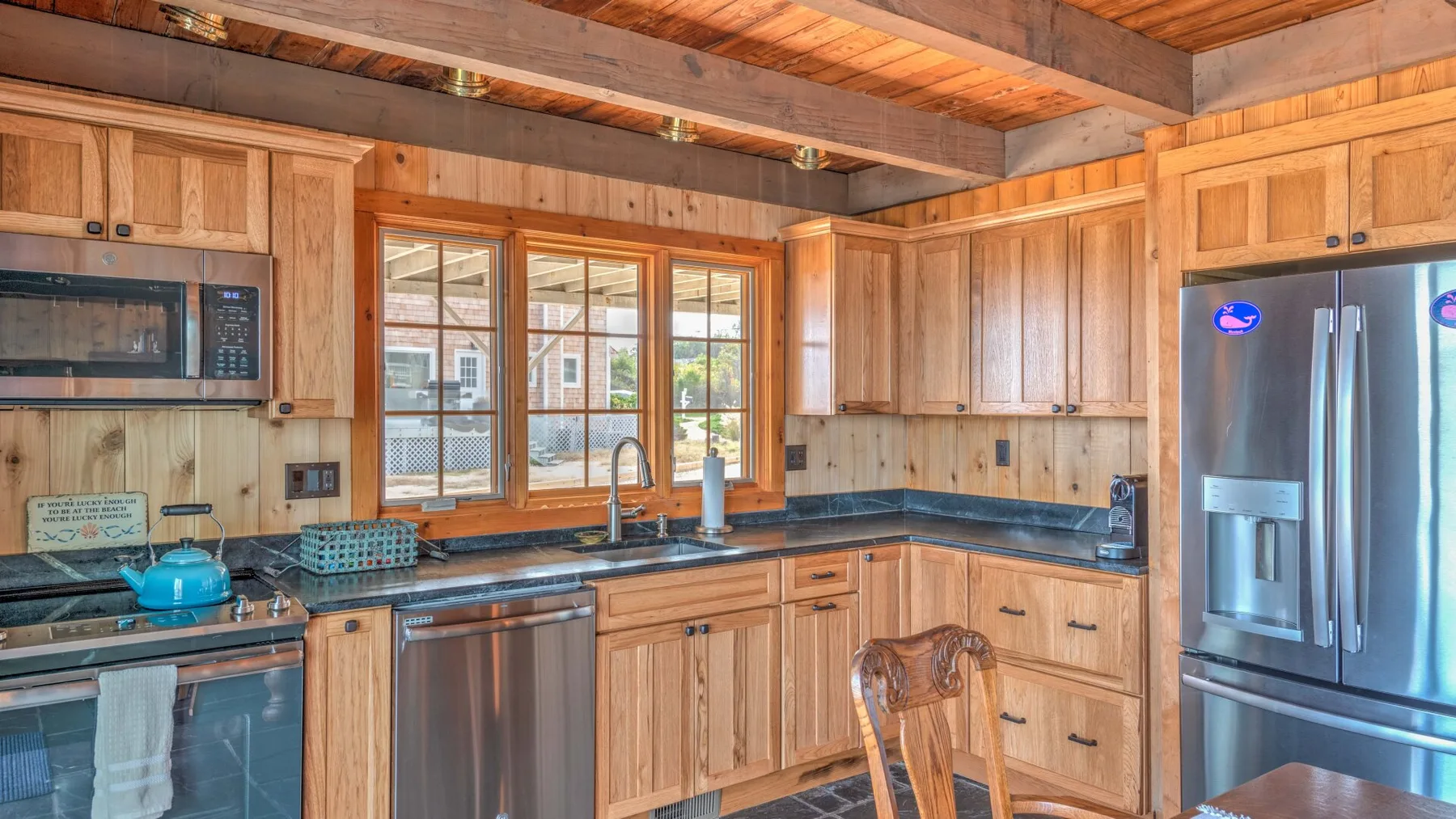 A wood-paneled kitchen with counters, a sink, and stainless steel appliances.