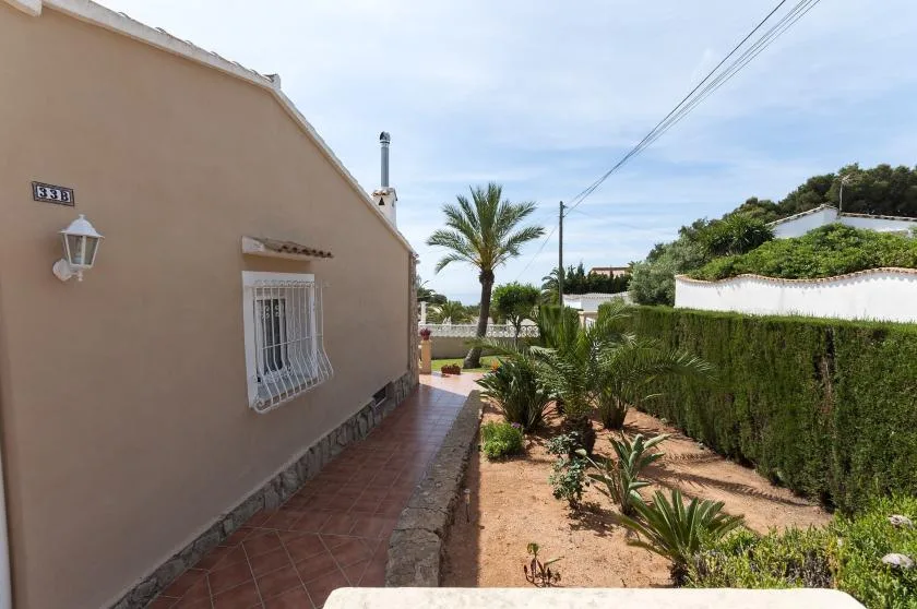 Exterior de una casa junto a un sendero de baldosas y un jardín.