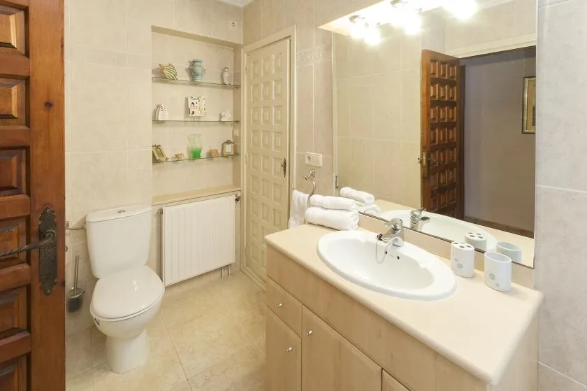 Un baño con lavabo, inodoro y toallas sobre la encimera.
