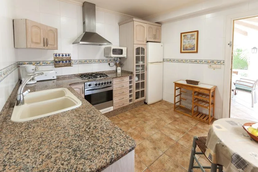 Una cocina luminosa con una encimera moteada, estufa y refrigerador.
