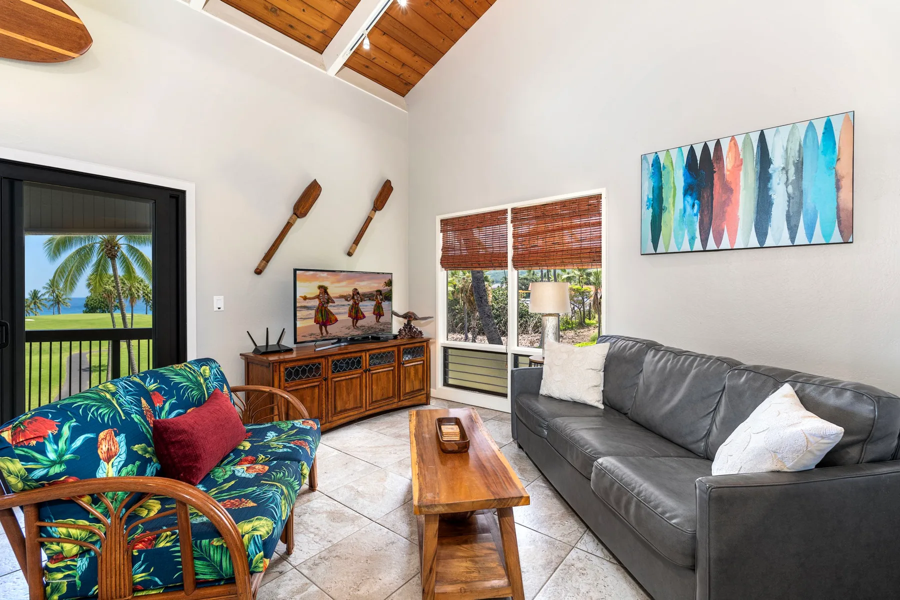 Una sala luminosa con un sofá gris, asientos coloridos y una mesa de centro de madera.