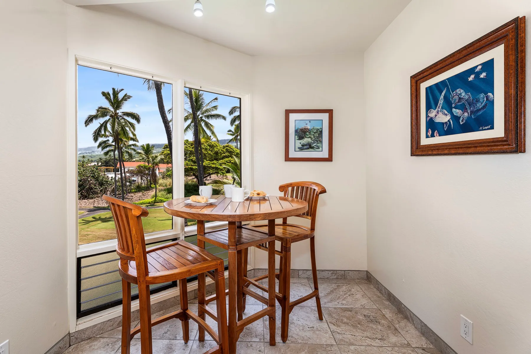 Un rincón de comedor con mesa y sillas de madera junto a grandes ventanas.