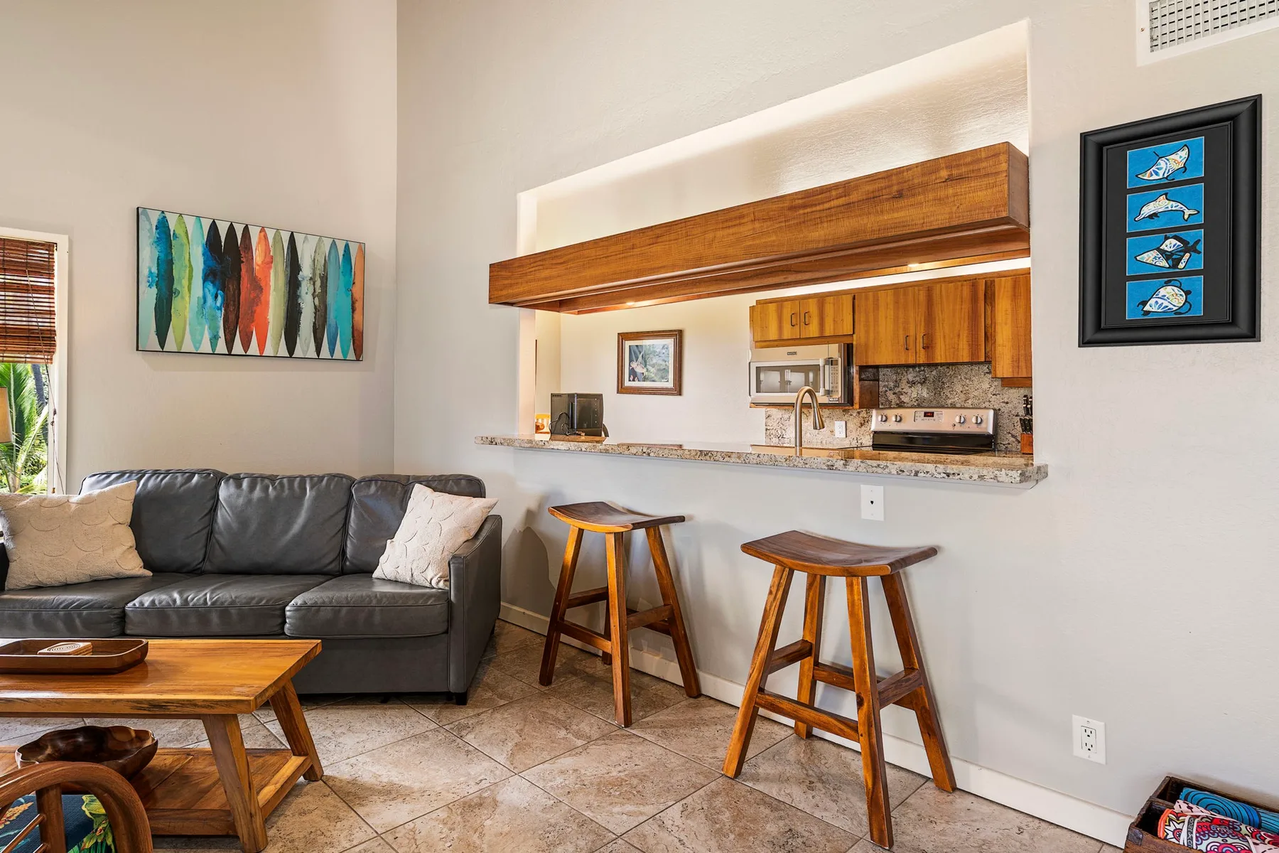 Una sala de estar da a una barra de cocina, con asientos y taburetes de madera.