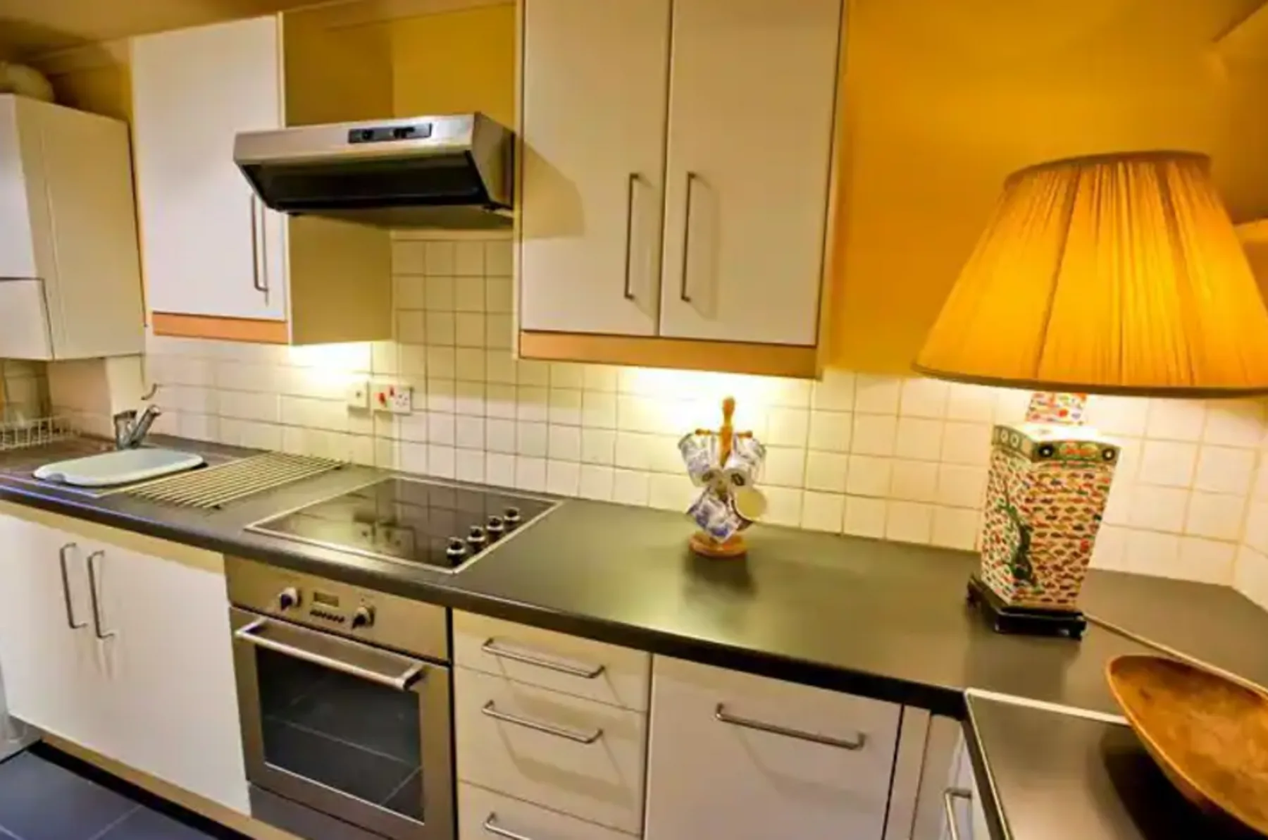 A kitchen with a tiled backsplash and countertop appliances.