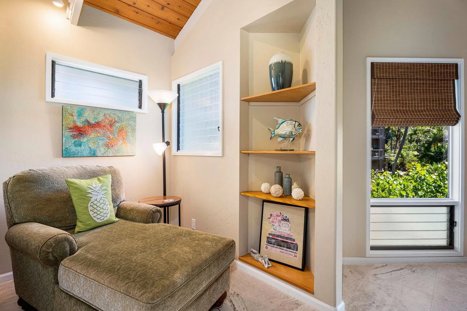 Una acogedora zona de estar con un sillón acolchado junto a estantes empotrados.