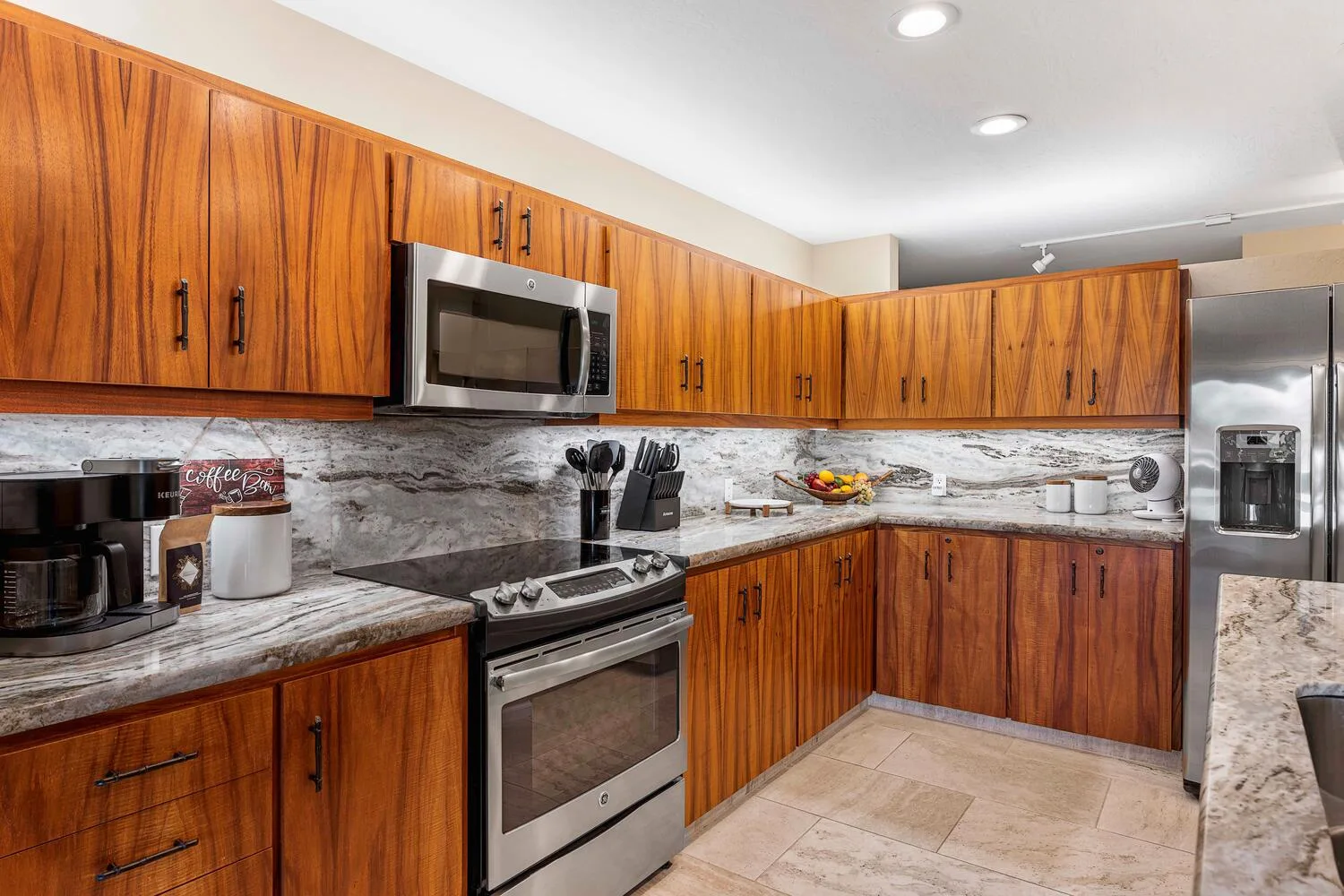 Una cocina con gabinetes de madera, una estufa de acero inoxidable y un refrigerador.
