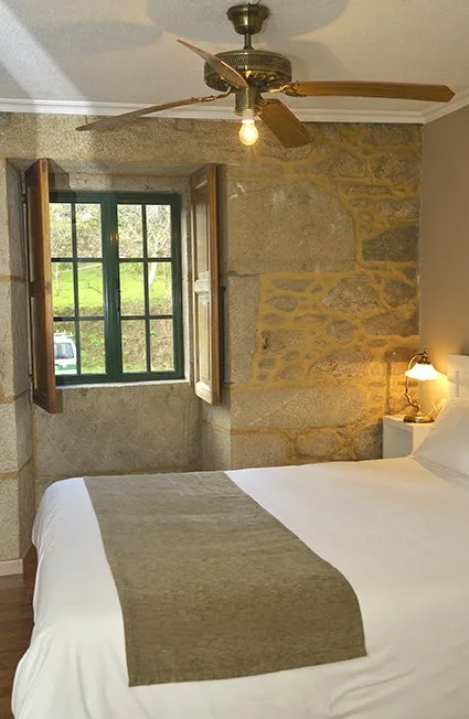 Habitación con una ventana de piedra que da al jardín