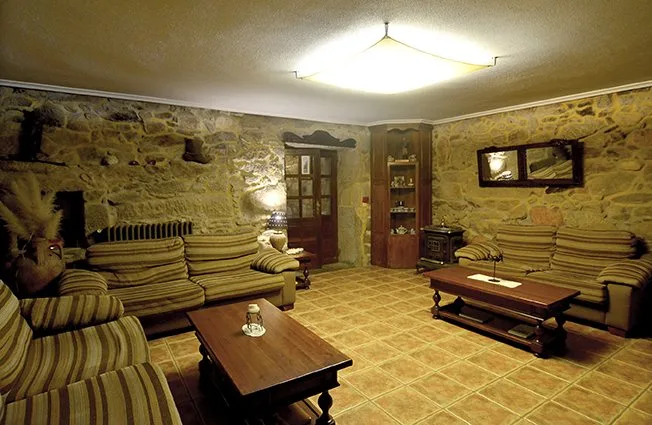 Sala de estar de Casa Rosalía con paredes de piedra vista