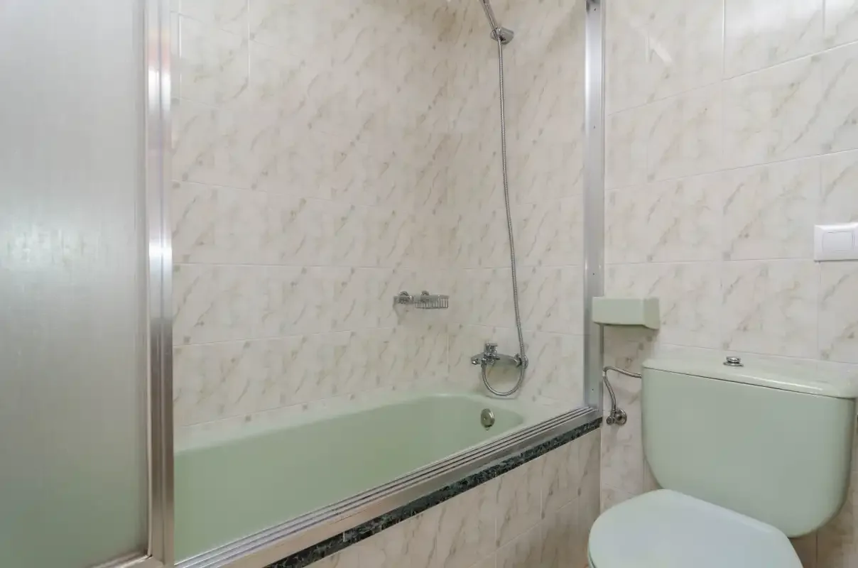 Un baño con bañera e inodoro.
