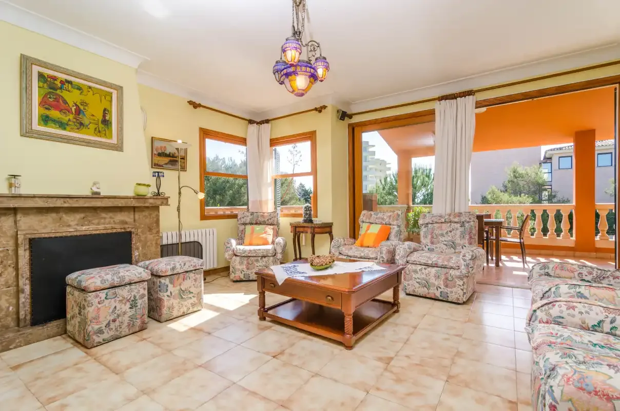 Una sala de estar con asientos estampados y una mesa de centro de madera.