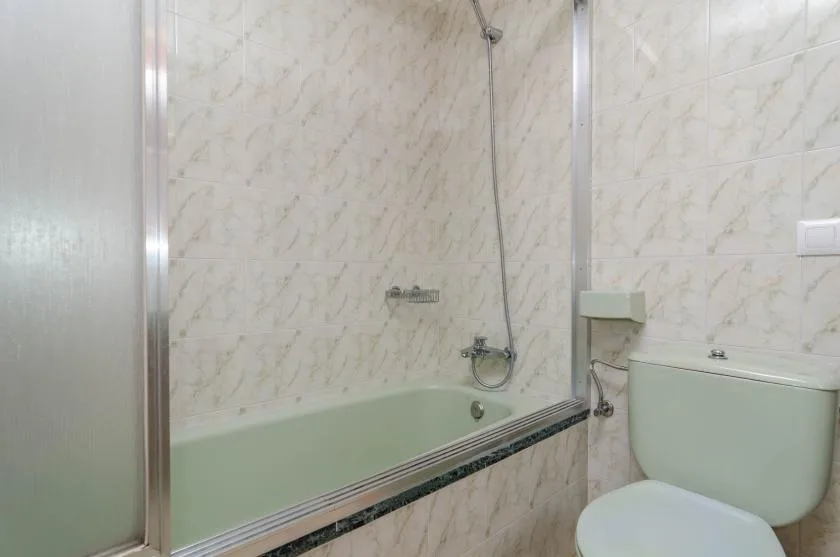 Un baño con bañera, ducha e inodoro.