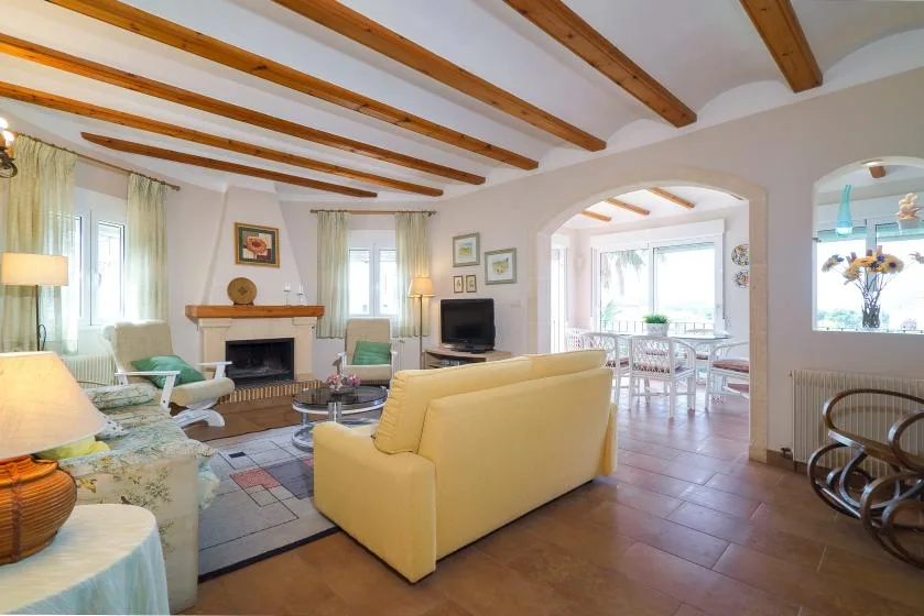 A living room with seating, a fireplace, and an arched opening to a dining area.