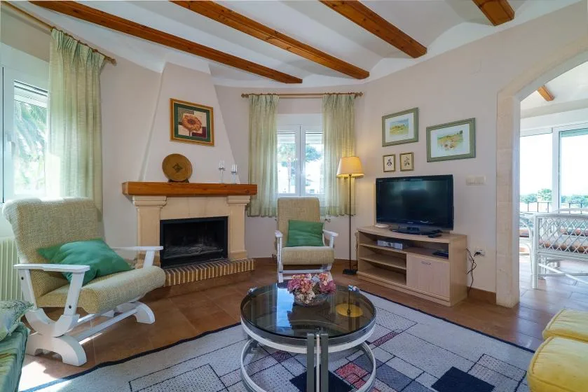 A living room with a fireplace, television, and seating around a coffee table.