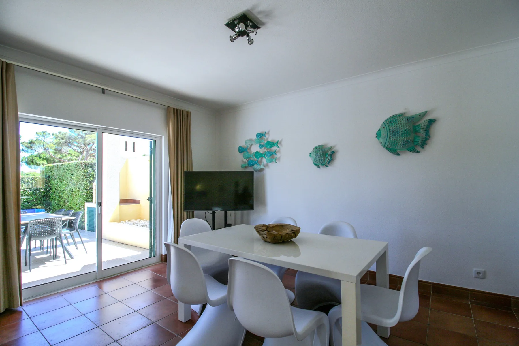 A dining area with a table and chairs beside sliding glass doors opening to a patio.