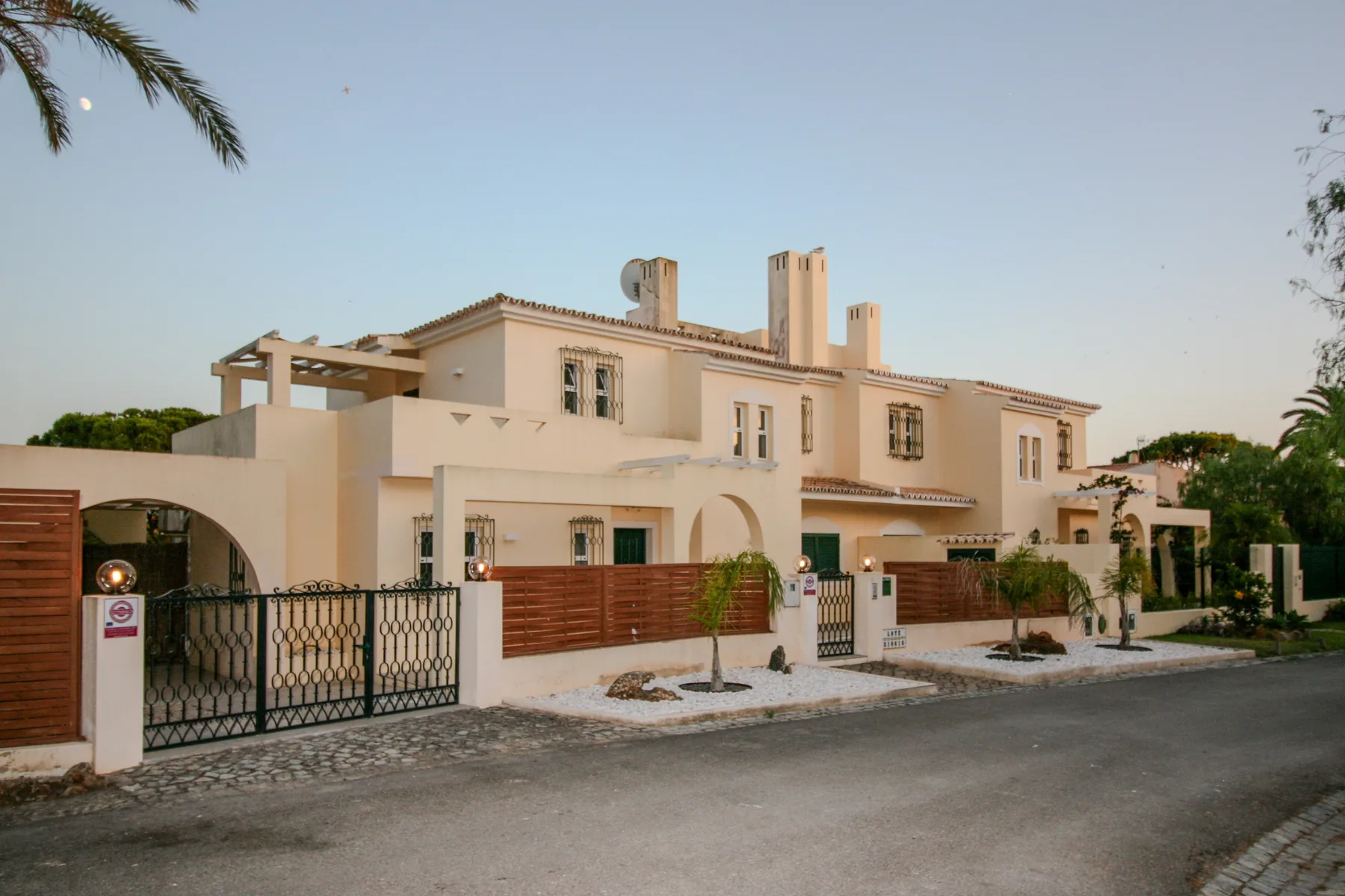 A row of pale stucco homes faces a paved residential street.