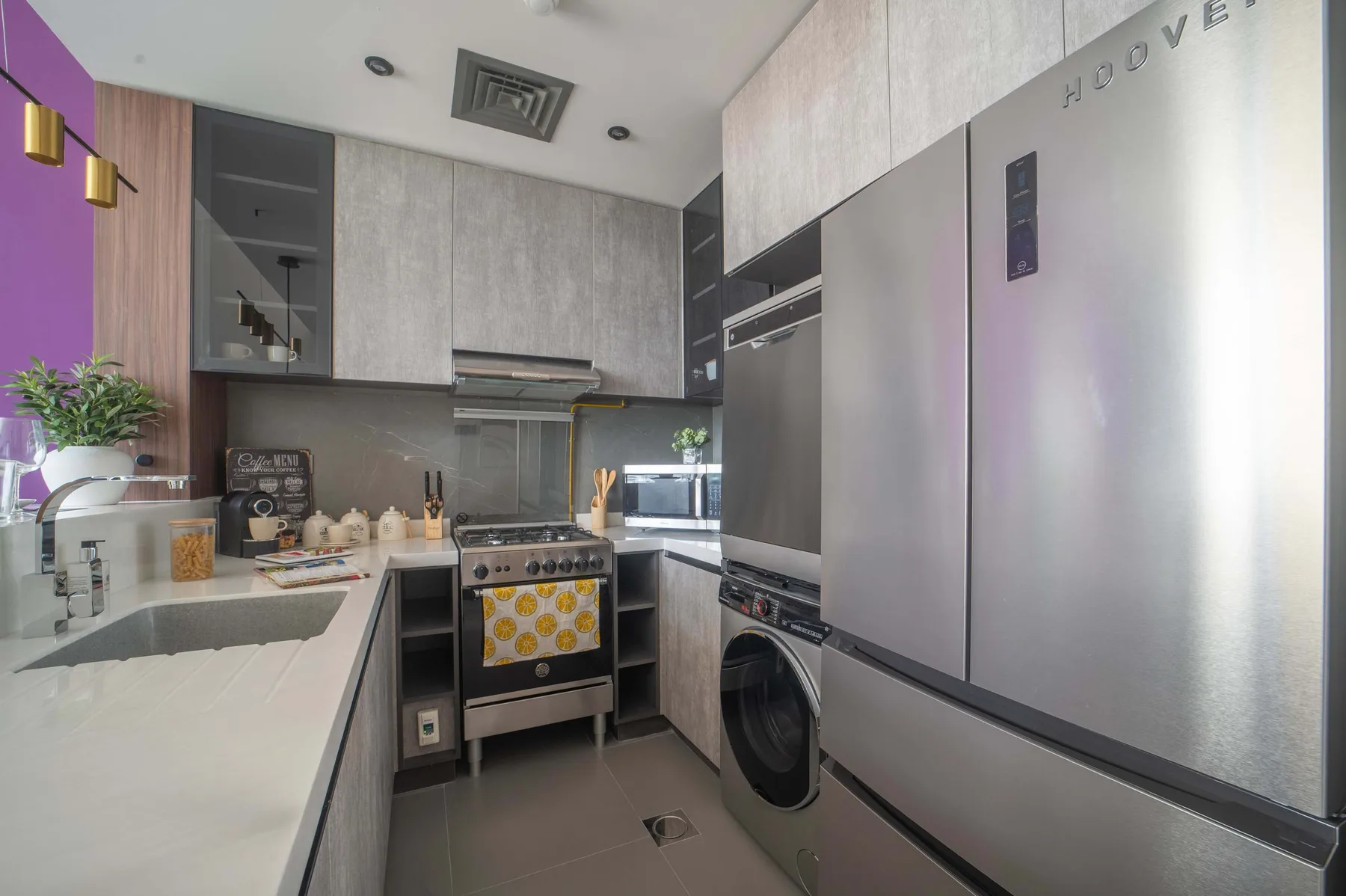 Una cocina moderna con una encimera larga, una estufa y electrodomésticos de acero inoxidable.