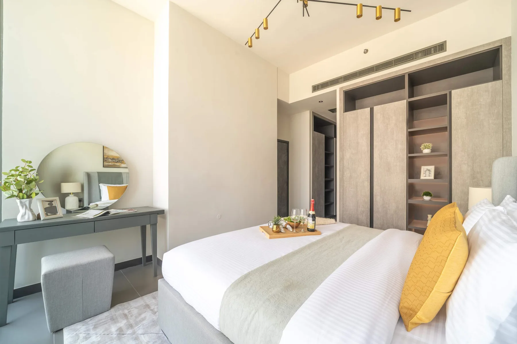 Un dormitorio luminoso con una cama, armarios empotrados y un escritorio.