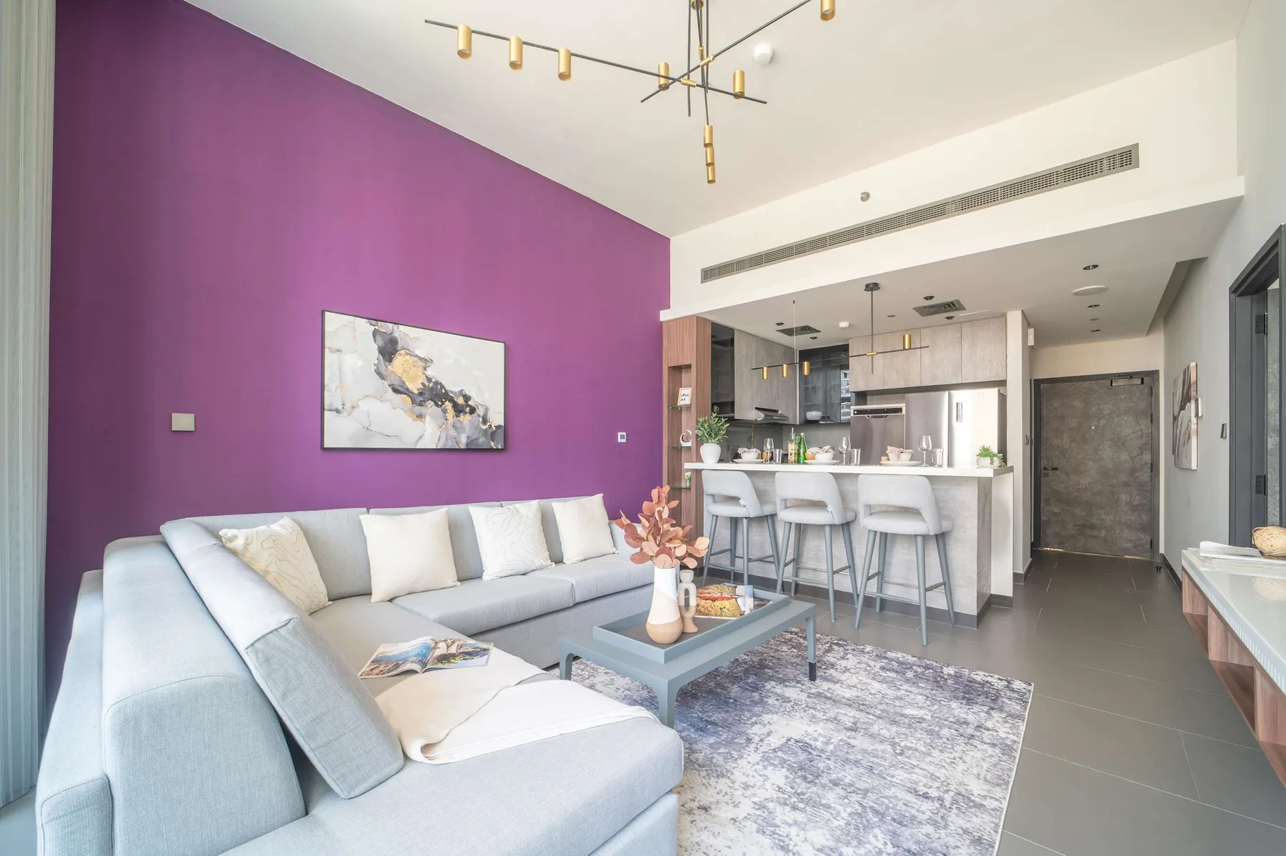 Una sala de estar con asientos y una mesa de centro junto a una cocina abierta.